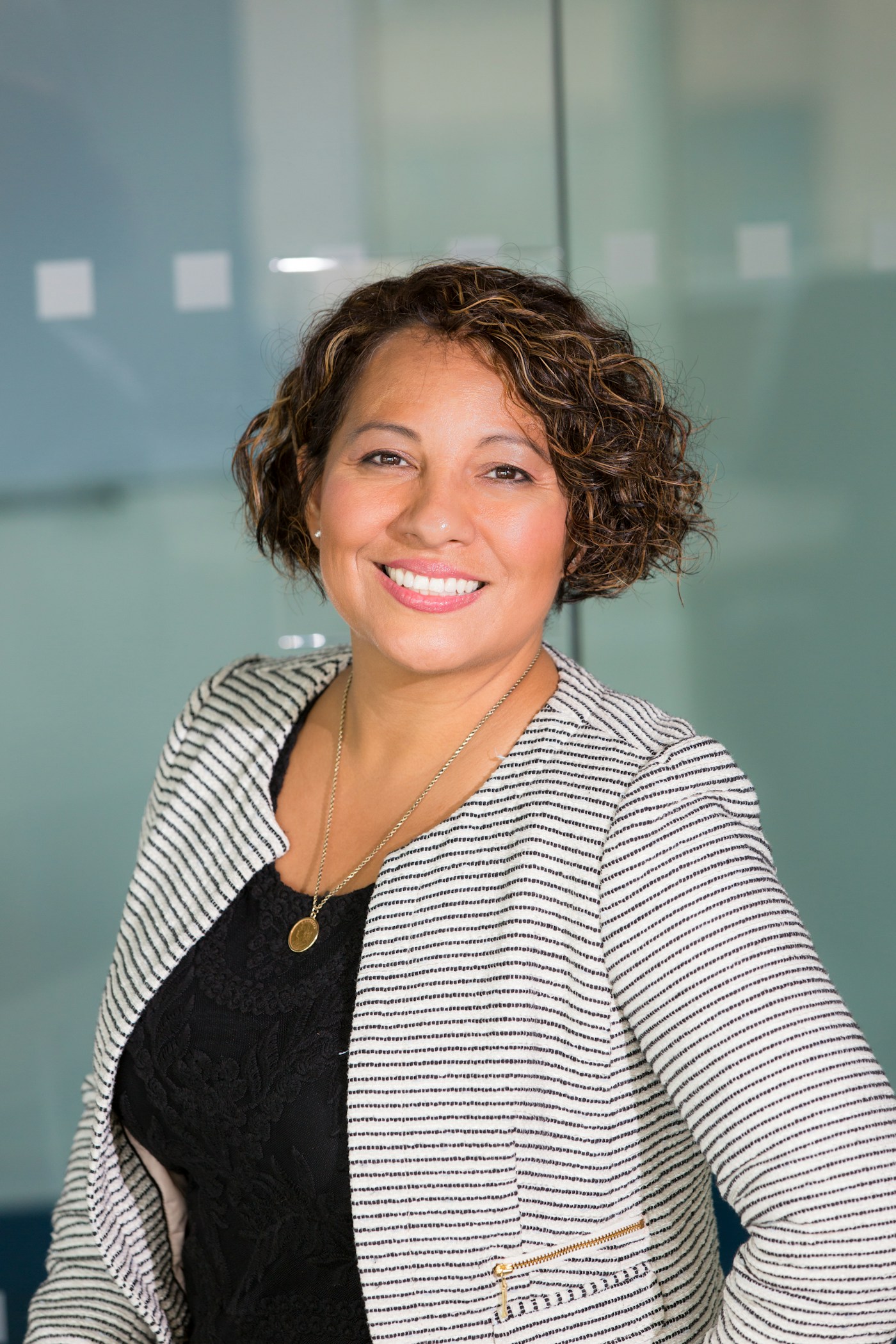 Portrait of a smiling professional woman in a striped blazer — the LinkedIn buyer persona