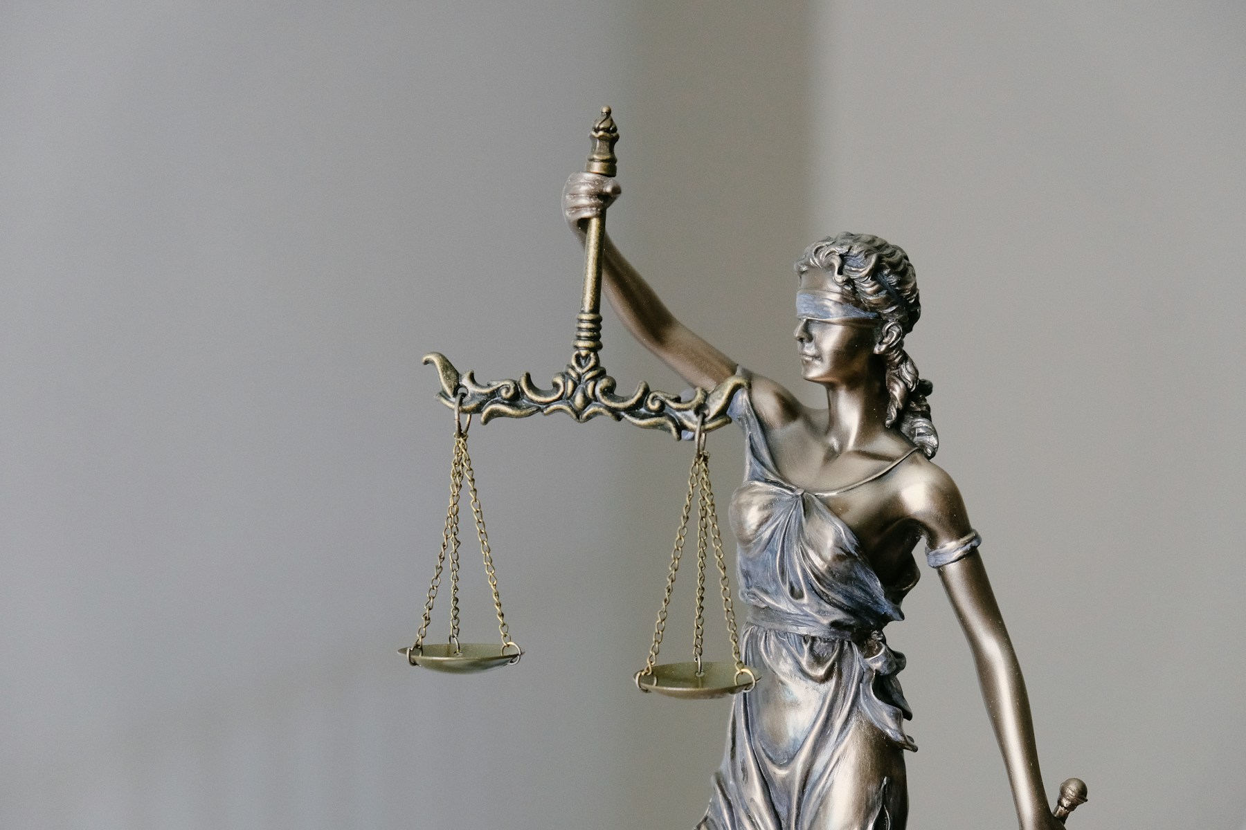Bronze Lady Justice statue holding the scales of justice