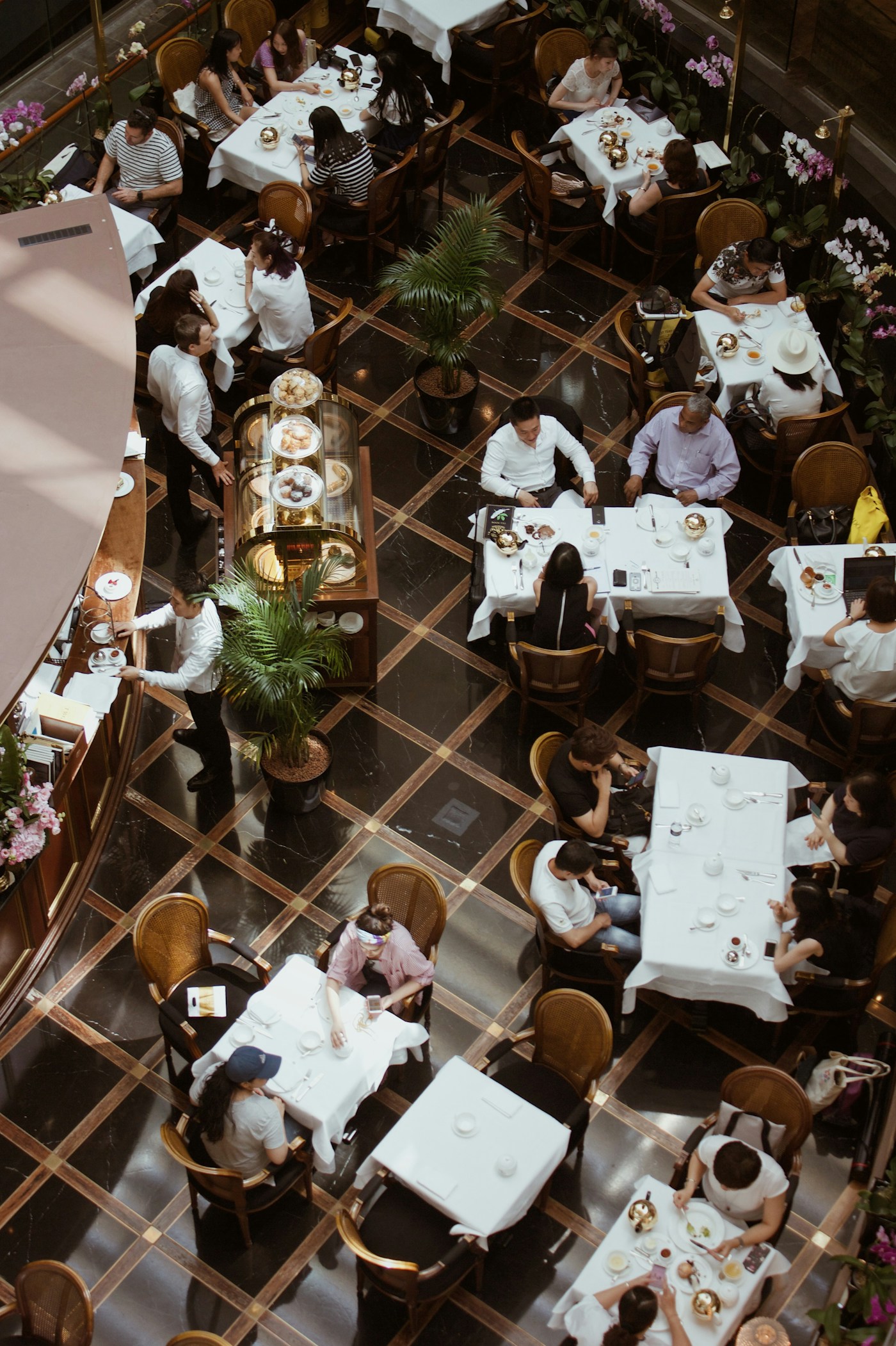 Busy upscale dining room seen from above, every table in service